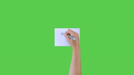 Woman-Writes-State-of-Emergency-on-Paper-on-Green-Screen