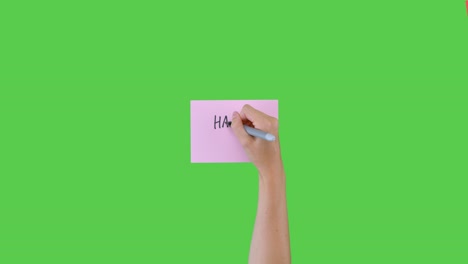 Woman-Writing-Happy-New-Year-on-Paper-with-Green-Screen-03