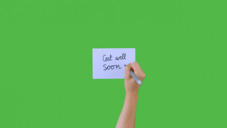Woman-Writing-Get-Well-Soon-on-Paper-with-Green-Screen