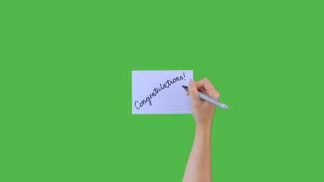 Woman-Writing-Congratulations-on-Paper-with-Green-Screen
