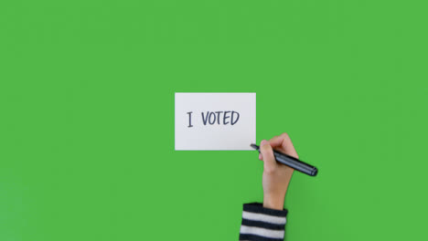 Woman-Writing-I-Voted-on-Paper-with-Green-Screen