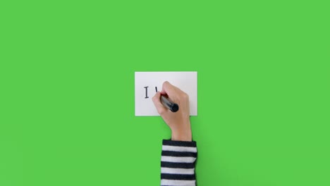 Woman-Writing-I-Voted-on-Paper-with-Green-Screen