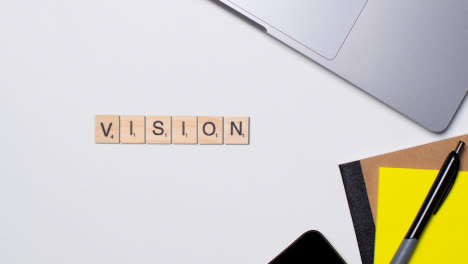 Stop-Motion-Business-Concept-Above-Desk-Wooden-Letter-Tiles-Forming-Word-Vision-1