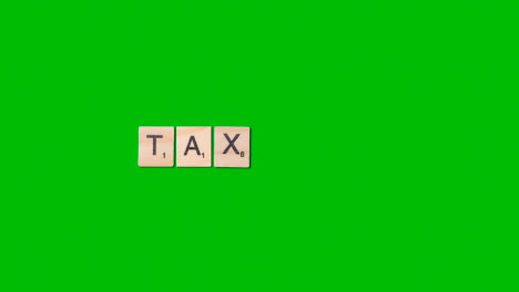 Stop-Motion-Business-Concept-Overhead-Wooden-Letter-Tiles-Forming-Word-Tax-On-Green-Screen