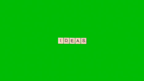 Stop-Motion-Business-Concept-Overhead-Wooden-Letter-Tiles-Forming-Word-Ideas-On-Green-Screen