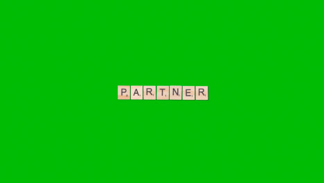 Stop-Motion-Business-Concept-Overhead-Wooden-Letter-Tiles-Forming-Word-Partner-On-Green-Screen