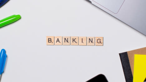 Stop-Motion-Business-Concept-Above-Desk-Wooden-Letter-Tiles-Forming-Word-Banking-1