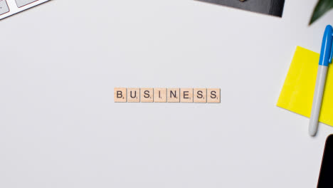 Stop-Motion-Business-Concept-Above-Desk-Wooden-Letter-Tiles-Forming-Word-Business