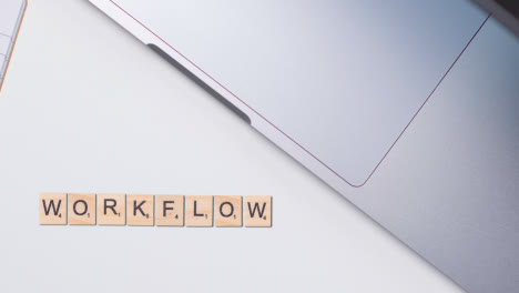Stop-Motion-Geschäftskonzept-über-Dem-Schreibtisch-Aus-Holzbuchstabenfliesen,-Die-Wort-Workflow-1-Bilden