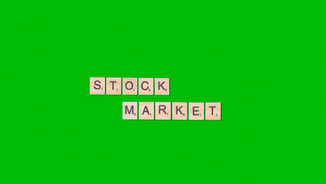 Stop-Motion-Business-Concept-Overhead-Wooden-Letter-Tiles-Forming-Words-Stock-Market-On-Green-Screen