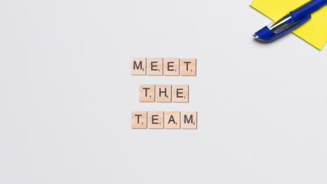 Stop-Motion-Business-Concept-Above-Desk-Wooden-Letter-Tiles-Forming-Words-Meet-The-Team