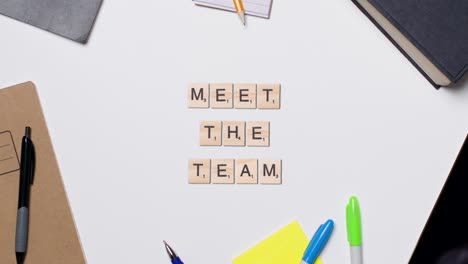 Stop-Motion-Business-Concept-Above-Desk-Wooden-Letter-Tiles-Forming-Words-Meet-The-Team-1