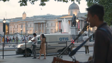 Busker-With-Guitar-Playing-To-Tourists-In-Trafalgar-Square-In-London-England-UK-2