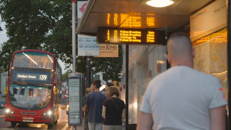 Passagiere,-Die-An-Der-Bushaltestelle-An-Einer-Stark-Befahrenen-Straße-In-London-England-UK-1-Warten
