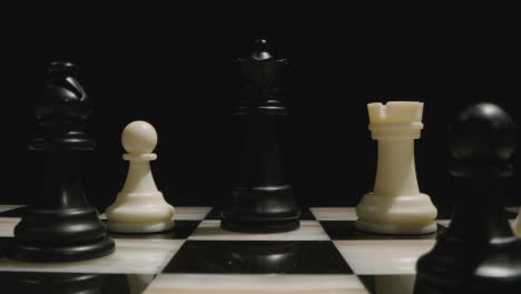 Pull-Back-From-Black-Queen-Across-Chess-Board-And-Pieces-Set-Up-For-Game