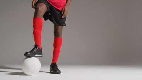 Close-Up-Of-Male-Footballer-In-Studio-Playing-Keepy-Uppy-Kicking-Ball-1