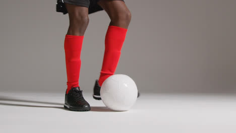 Close-Up-Of-Male-Footballer-In-Studio-Kicking-Ball