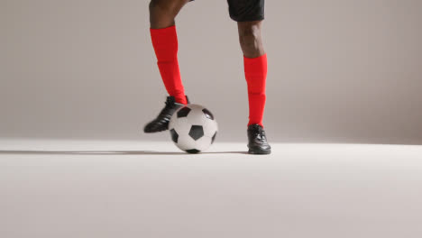 Close-Up-Of-Male-Footballer-In-Studio-Controlling-And-Flicking-Ball-Into-The-Air-1