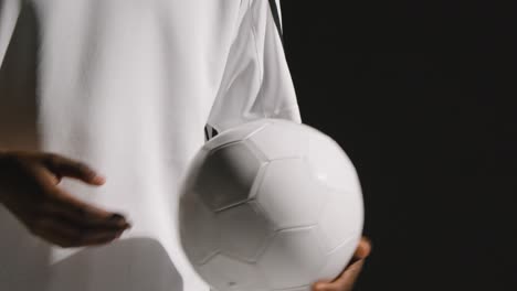 Close-Up-Of-Male-Footballer-In-Studio-With-Ball-Under-Arm-2