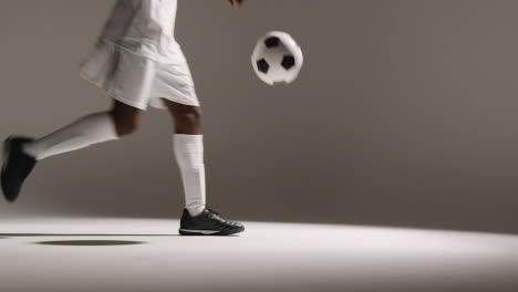 Studio-Close-Up-Of-Male-Footballer-Wearing-Club-Kit-Controlling-Ball-With-Chest-And-Passing-1