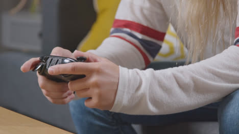 Close-Up-Of-Woman-Sitting-On-Sofa-At-Home-Gaming-Online