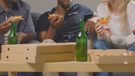 Multi-Cultural-Friends-Sitting-On-Sofa-At-Home-Eating-Takeaway-Pizza-Delivery-And-Drinking-Beer-7