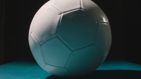 Studio-Still-Life-Shot-Of-Football-Or-Soccer-Ball-Against-Black-Background-