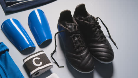 Studio-Still-Life-Shot-Of-Football-Soccer-Boots-Ball-Shin-Guards-And-Captains-Armband-1