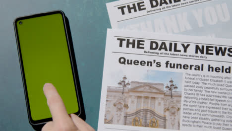 Top-View-of-Queen-Elizabeth-Death-Newspaper-Headlines-with-Green-Screen-Phone-04