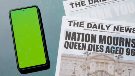 Tracking-Shot-of-Queen-Elizabeth-Death-Newspaper-Headlines-with-Green-Screen-Phone-02