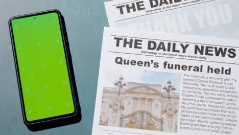 Tracking-Shot-of-Queen-Elizabeth-Death-Newspaper-Headlines-with-Green-Screen-Phone-04