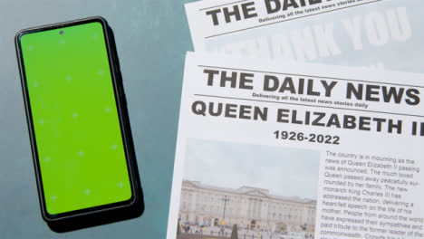 Tracking-Shot-of-Queen-Elizabeth-Death-Newspaper-Headlines-with-Green-Screen-Phone-05
