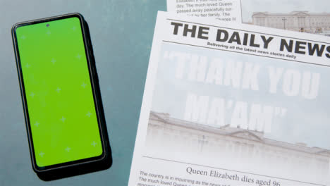Tracking-Shot-of-Queen-Elizabeth-Death-Newspaper-Headlines-with-Green-Screen-Phone-06