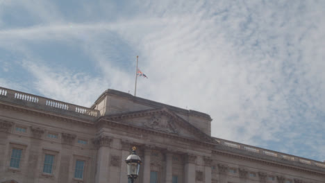 Tilting-Shot-of-Buckingham-Palace's-United-Kingdom-Flag-Flying-at-Half-Mast