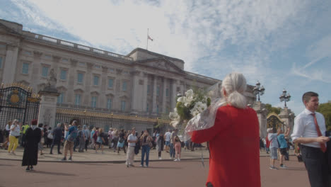 Wide-Shot-of-a-Mourner-Holding-Flowers-Outside-Buckingham-Palace