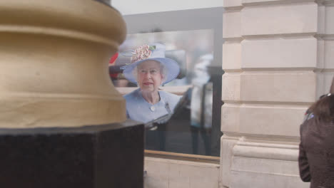 Wide-Shot-of-Pedestrians-Walking-Past-Portrait-of-Queen-Elizabeth-II