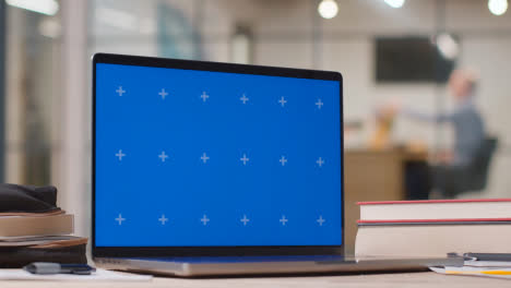 Laptop-Mit-Blauem-Bildschirm-Auf-Dem-Schreibtisch-Im-Geschäftigen-Modernen-Büro-2