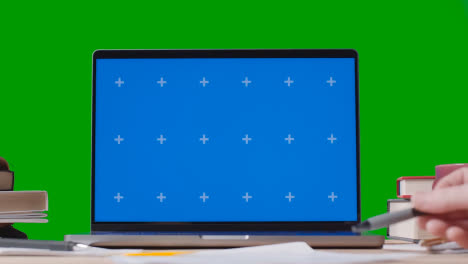 Blue-Screen-Laptop-With-Books-On-Table-With-Green-Screen-Background-Education-Concept-2