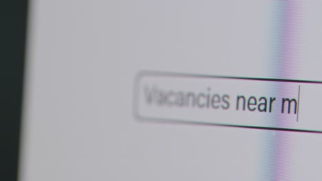 Close-Up-Of-Screen-With-Person-Typing-Vacancies-Near-Me-Into-Computer-Search-Engine