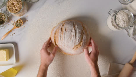 Overhead-Shot-Of-Freshly-Baked-Loaf-Of-Bread-On-Marble-Surface-With-Digital-Tablet