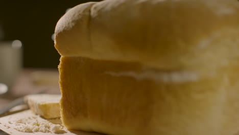 Nahaufnahme-Einer-Person,-Die-Brot-Und-Butter-Isst,-Mit-Geschnittenem-Laib-Im-Vordergrund-1