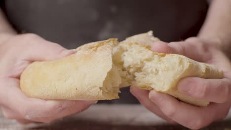 Close-Up-Studio-Shot-Of-Person-Tearing-Open-Fresh-Bread-Roll-1