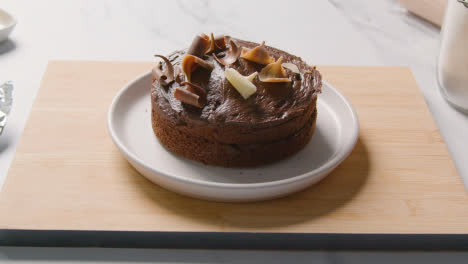 Homemade-Chocolate-Cake-On-Plate-On-Kitchen-Work-Surface-With-Ingredients