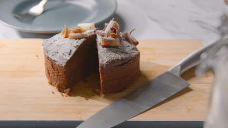 Homemade-Chocolate-Cake-On-Kitchen-Work-Surface-With-Slice-Cut-Out