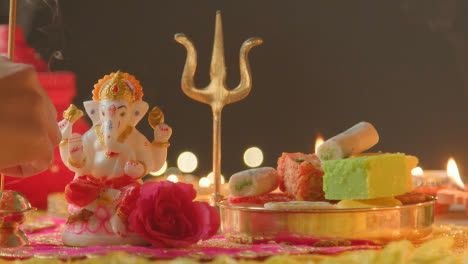 Person-Holding-Incense-Stick-With-Decorations-Celebrating-Festival-Of-Diwali