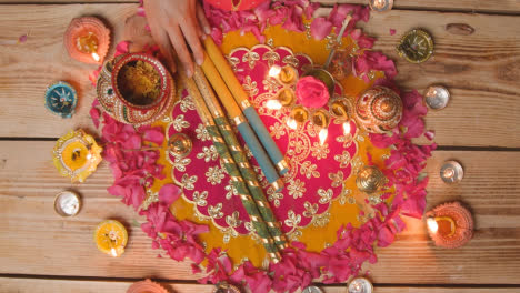 Overhead-Shot-Of-Person-Preparing-Decorative-Scene-To-Celebrate-Festival-Of-Diwali