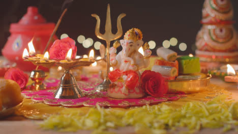 Lámpara-De-Cinco-Mechas-Y-Estatua-De-Ganesh-En-Una-Mesa-Decorada-Celebrando-El-Festival-De-Diwali-1
