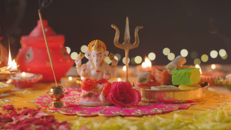 Persona-Sosteniendo-Un-Palo-De-Incienso-Junto-A-La-Estatua-De-Ganesh-En-Una-Mesa-Decorada-Celebrando-El-Festival-De-Diwali