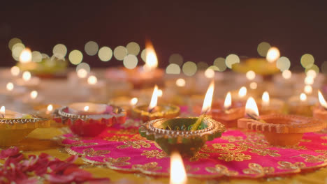 Person,-Die-Eine-Brennende-Diya-Lampe-Auf-Einen-Tisch-Stellt,-Der-Dekoriert-Ist,-Um-Das-Fest-Von-Diwali-1-Zu-Feiern