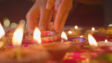 Person,-Die-Eine-Brennende-Diya-Lampe-Auf-Einen-Tisch-Stellt,-Der-Dekoriert-Ist,-Um-Das-Fest-Von-Diwali-4-Zu-Feiern